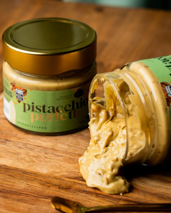 Potes de Pistacchio Perfetto abertos sobre tábua de madeira