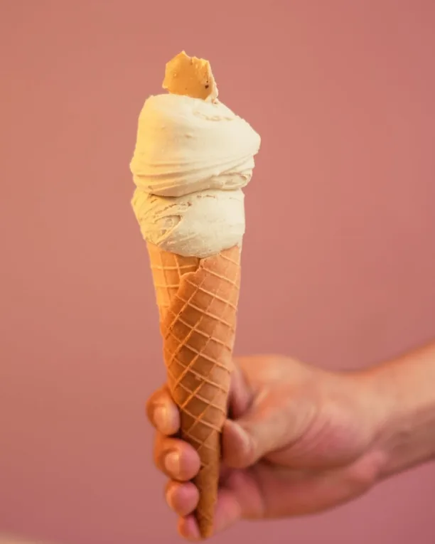 Cascão artesanal com gelato de creme, segurado na mão